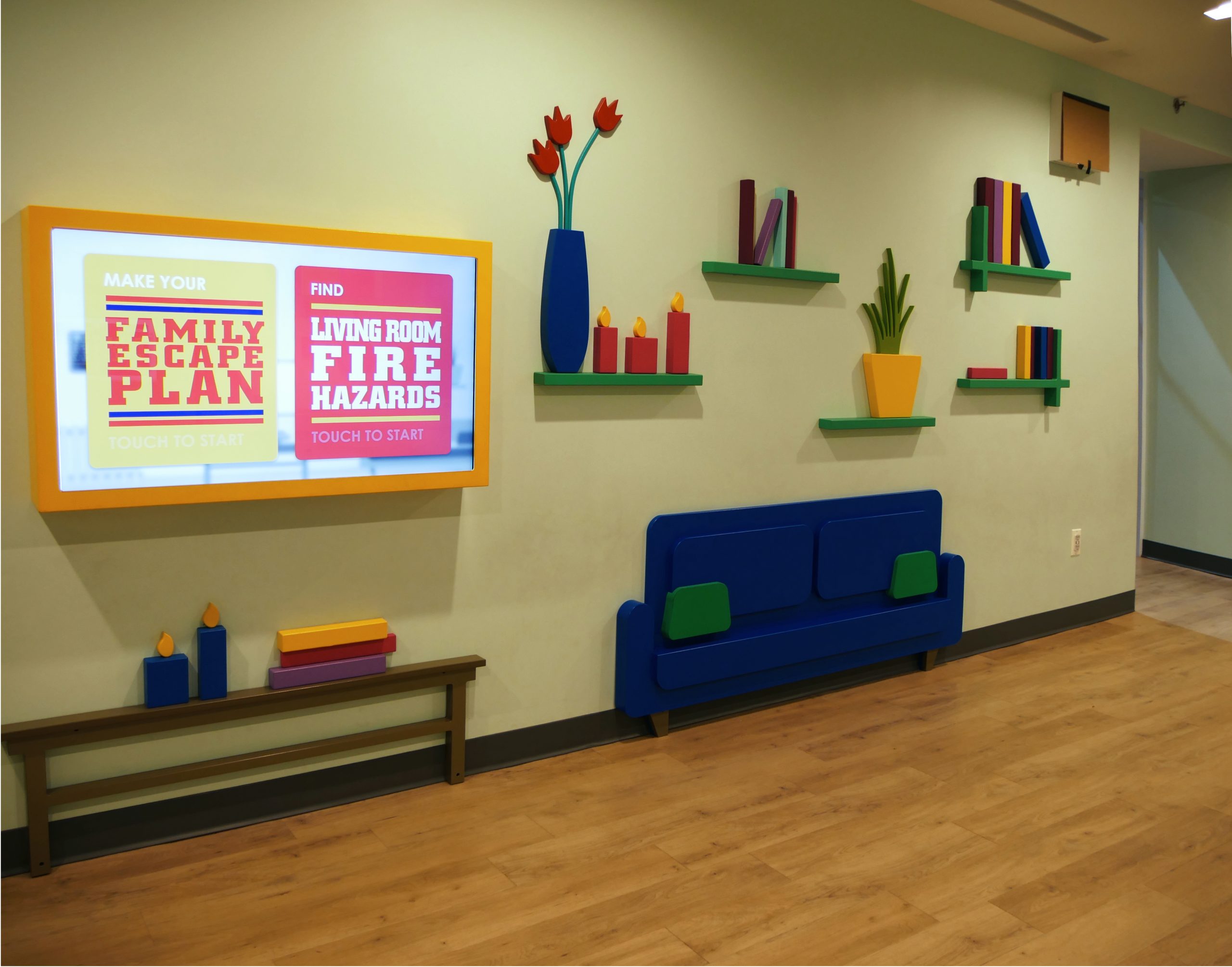 Exhibit Wall mimicing interior of a home with wall monitor featuring museum logo