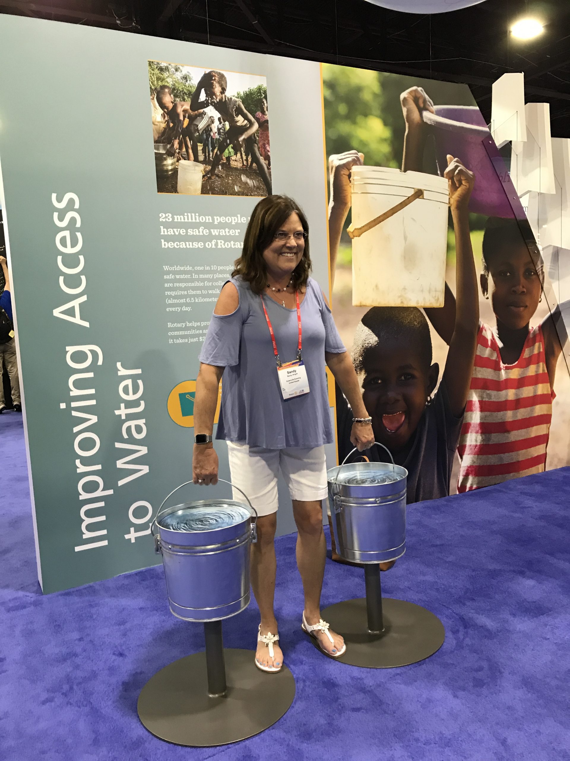 Woman standing in front of dusplay that says Improving Access to Water