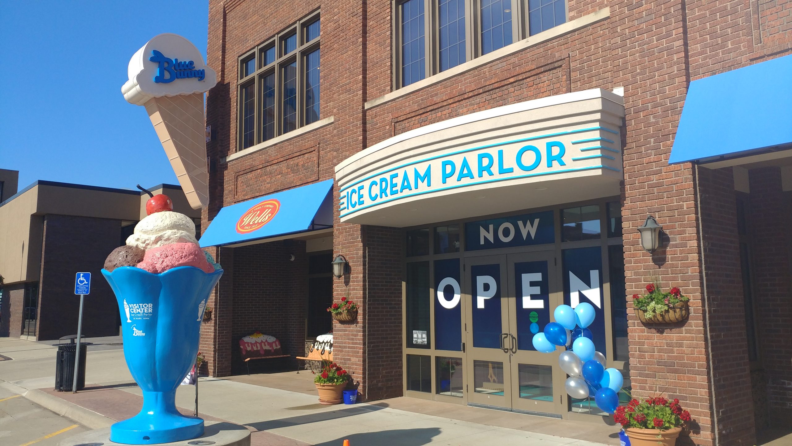 Entrance to the Blue Bunny visitor center with large signage saying "Ice Cream Parlor" and large sculptural display of an ice cream sundae.