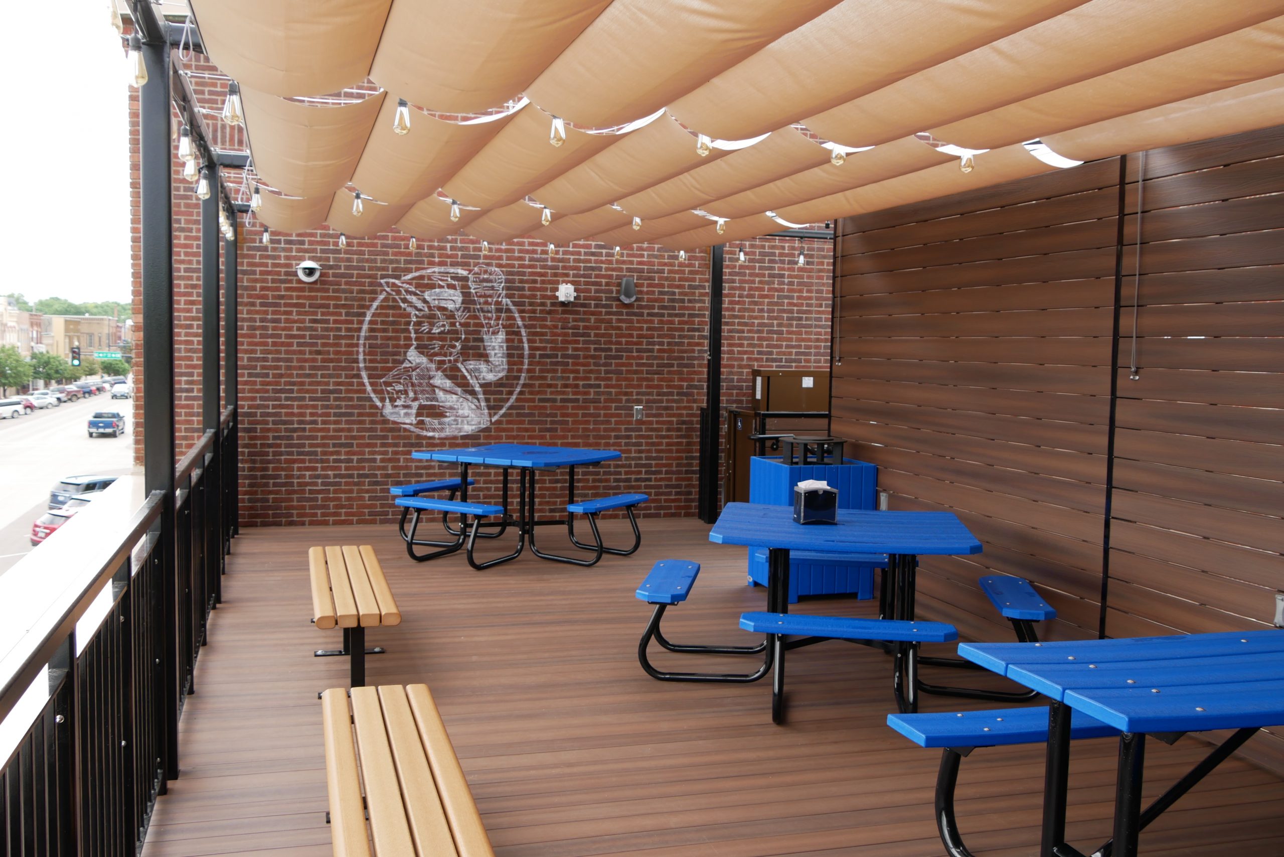 Outdoor balcony area with picnic table guest seating and Blue Bunny logo on brick wall