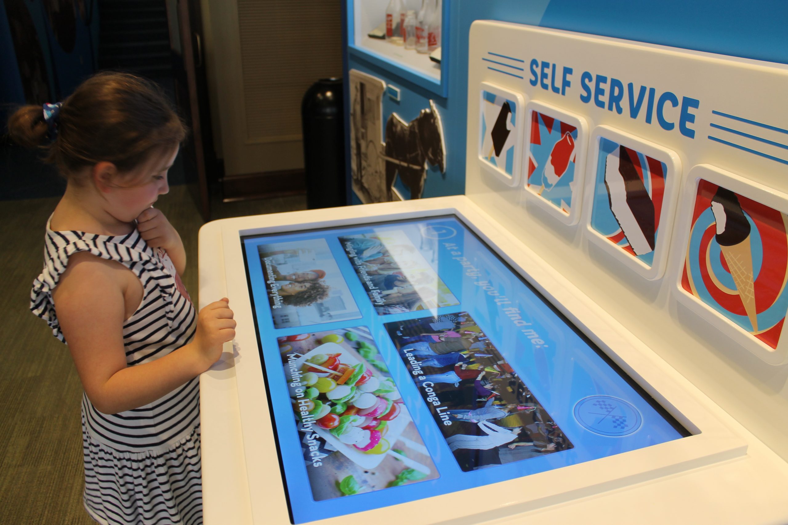 Young girl interacting with tabletop touchscreen interactive