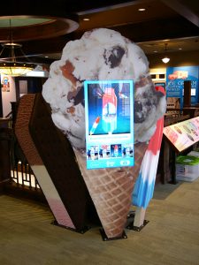 Touchscreen display fitted to large than life ice cream cone backdrop