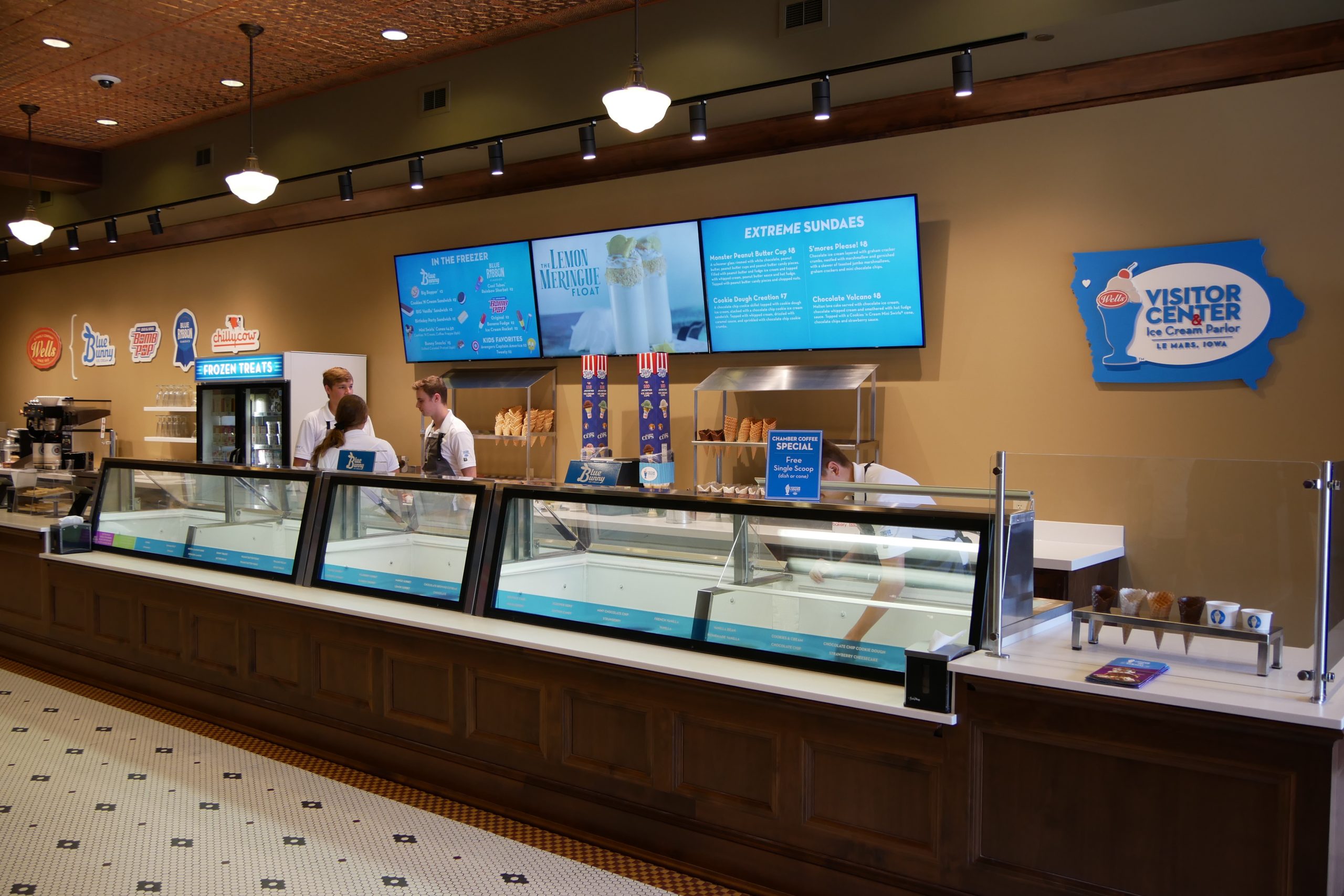 View of Visitor Center ice cream shop with staff standing behind the coolers ready to scoop out ice cream.